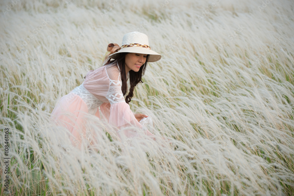 Beautiful girl in pink dress ,background of feather grass