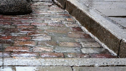 Rain plattering on cobblestones in the edge of a pavement. photo