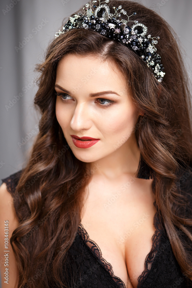 Elegant young woman with perfect makeup and hair style in a black dress with diadem and earrings. Beauty fashion portrait with accessories Elegant young woman with perfect makeup and hair style in a black dress with diadem and earrings. Beauty fashion portrait with accessories