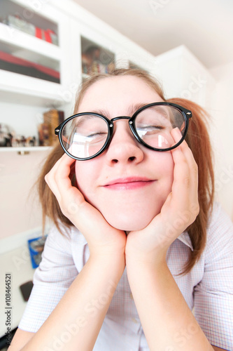 Funny nerdy girl with ponytails in eyeglasses dreaming about hol