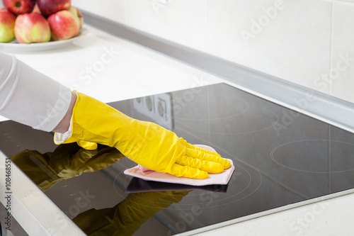 Housewife cleaning an induction plate