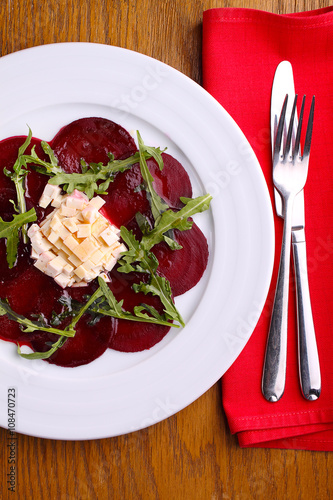 beet salad and cheese and arugula in a white plate