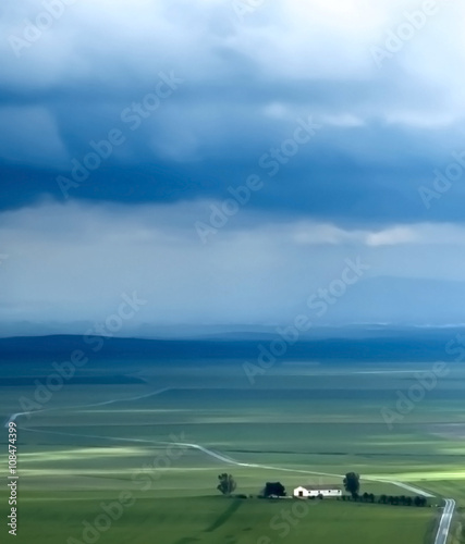 Valley landscape in a stormy day with large rain clouds
