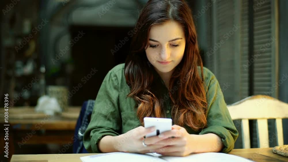 Absorbed girl sitting in the cafe and texting on smartphone
Absorbed girl sitting in the cafe and texting on smartphone