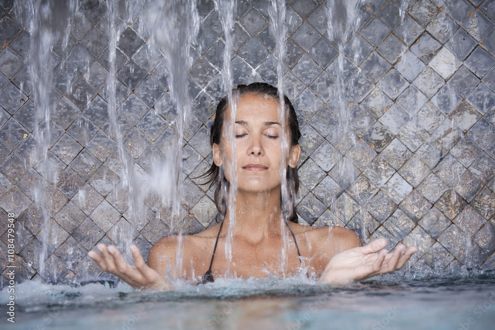 © plprod - belle femme sous une cascade dans une piscine