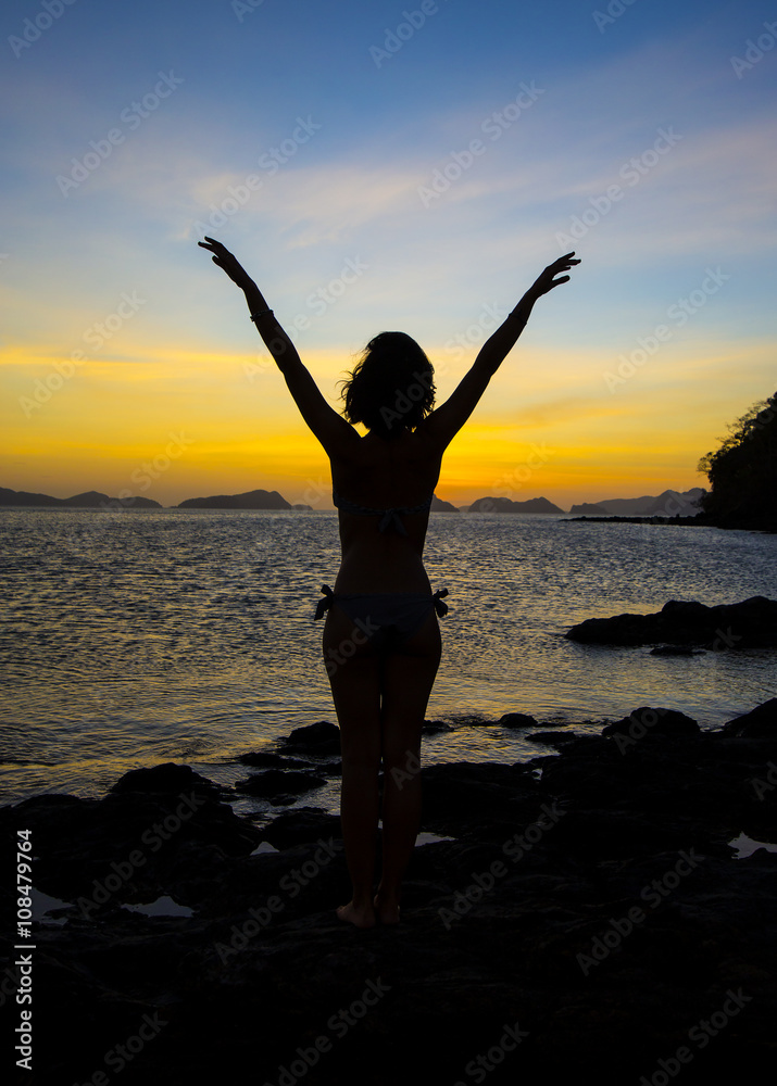 girl in a yoga pose meditating at sunset