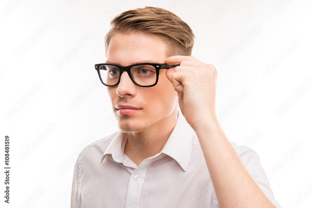 Attractive young man in white shirt touching his glasses