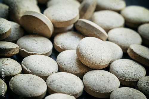 Brewer's yeast tablets on a dark background, selective focus, sh