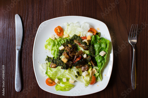 Vegetable salad on white plate on wooden table. Lenten menu