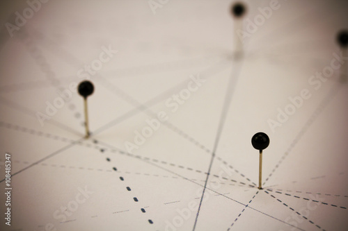 Black pins in paper linked by lines