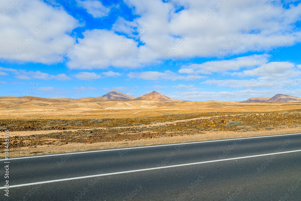 Fototapeta premium Road to Corralejo along desert with volcanoes, Fuerteventura, Canary Islands, Spain