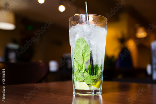 Mahito cocktail with mint on wooden table in restaurant
