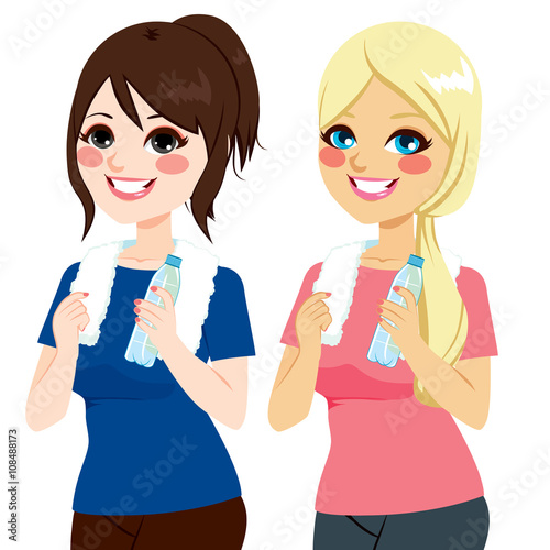 Beautiful fit young women in sportswear with bottle of mineral water and white clean towel