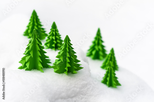 Weihnachtliche Miniaturlandschaft, Frohe Weihnachten, Papiertannenbäume im Schnee, schlichte Weihnachtskarte in Weiß und Grün, plakativ, Textfreiraum, Winterlandschaft