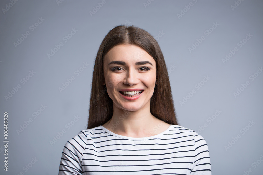 Positive girl standing isolated on grey background Positive girl standing isolated on grey background