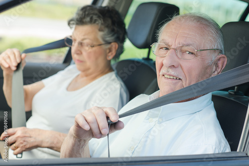 elderly couple putting seat belt