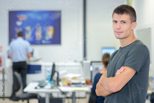 Young man with arms crossed in computer room