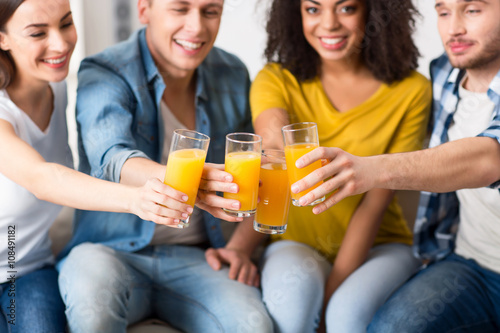 Delighted friends drinking juice