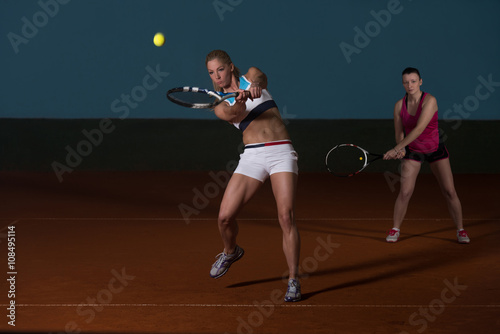 Two Sporty Female Tennis Players Enjoying A Game