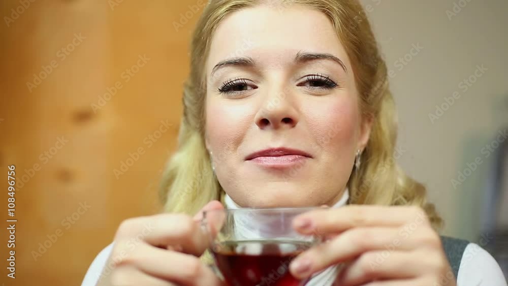 Positive smiling lady drinking hot black tea and looking charmingly into camera Positive smiling lady drinking hot black tea and looking charmingly into camera