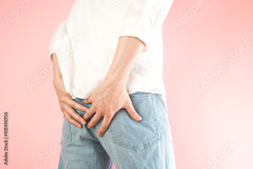 お尻を押さえる男性