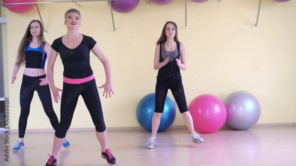Tree girls making fitness exercises synchronously in a gym. 4k Tree girls making fitness exercises synchronously in a gym. 4k