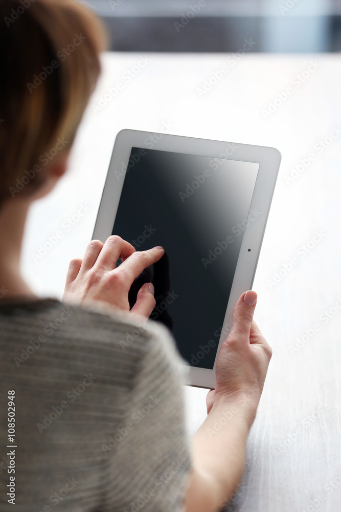 Young woman using tablet at the table
