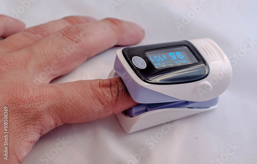 Pulse oximeter on the patient's hand photo
