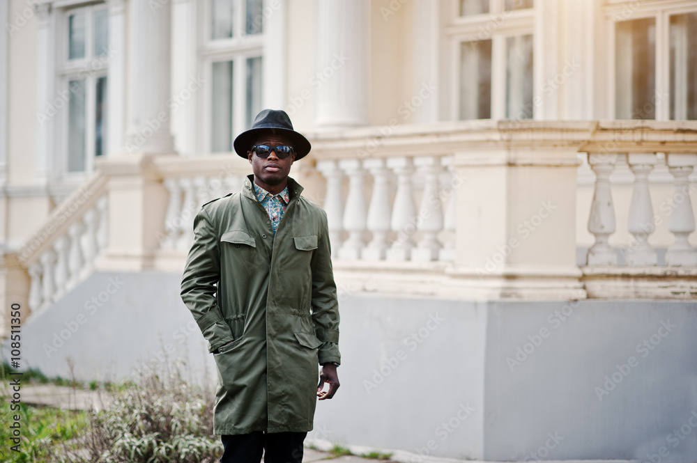 Naklejka premium Fashion portrait of black african american man on green coat clo