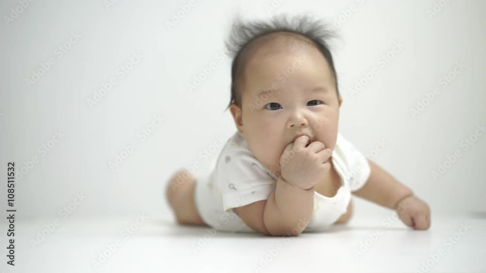 Asian chinese baby turning onto her tummy as a milestone Asian chinese baby turning onto her tummy as a milestone