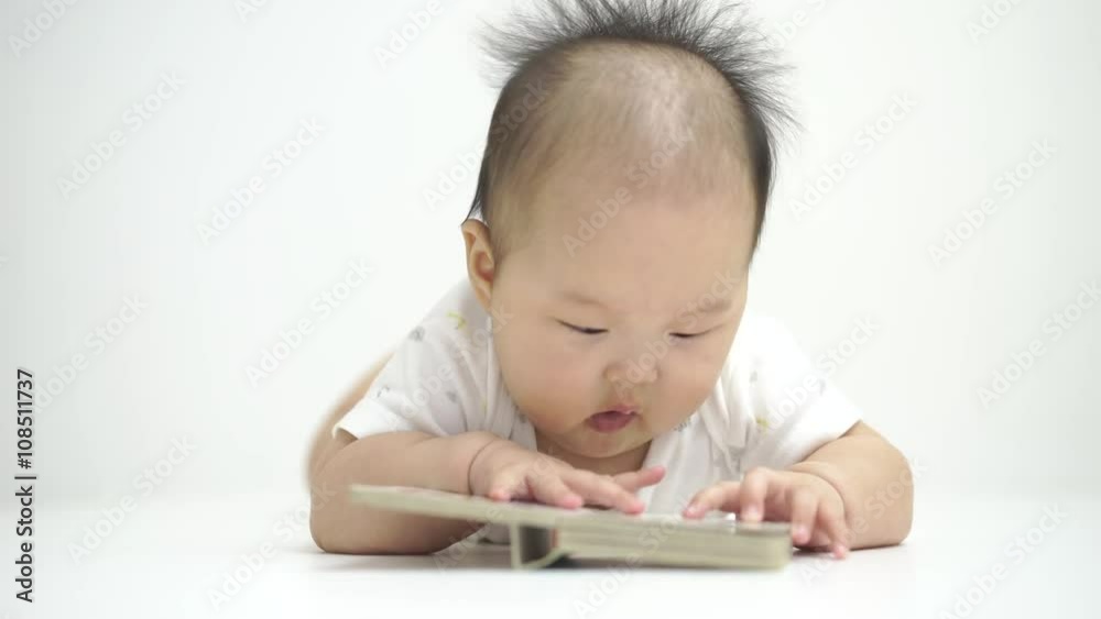 Asian chinese baby reading a cute little tiny book. Asian chinese baby reading a cute little tiny book.
