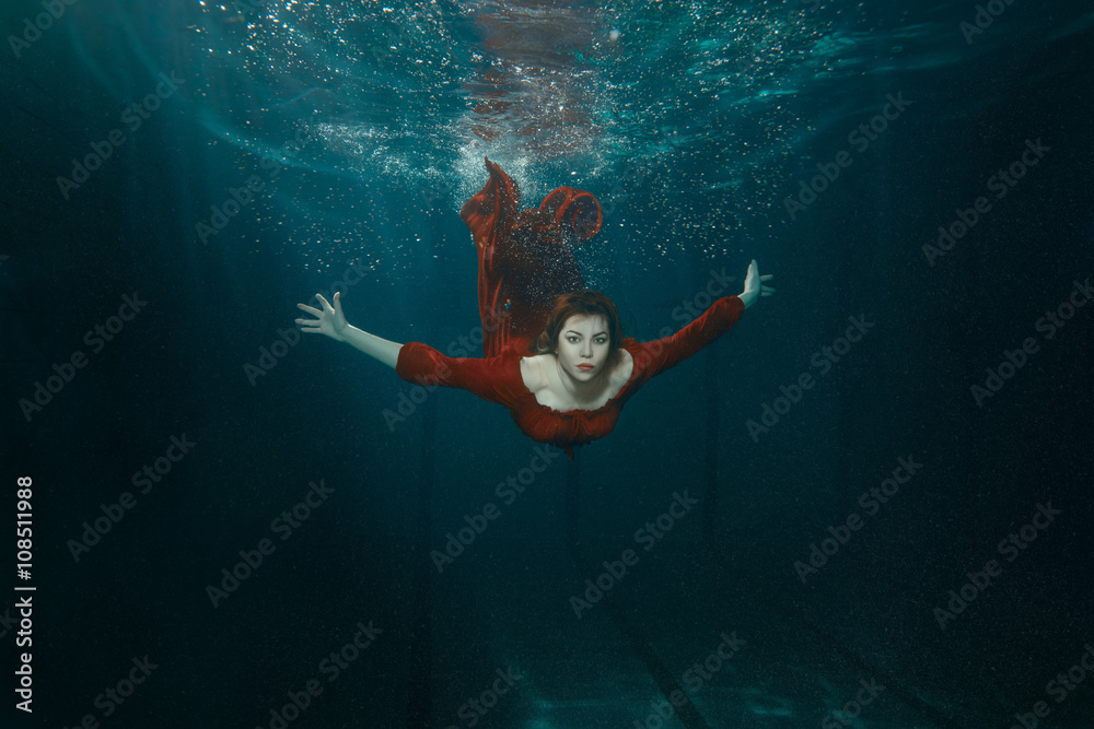 Woman in a dress dives.