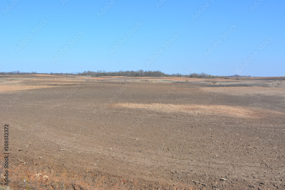 Вспаханное поле на фоне голубого неба