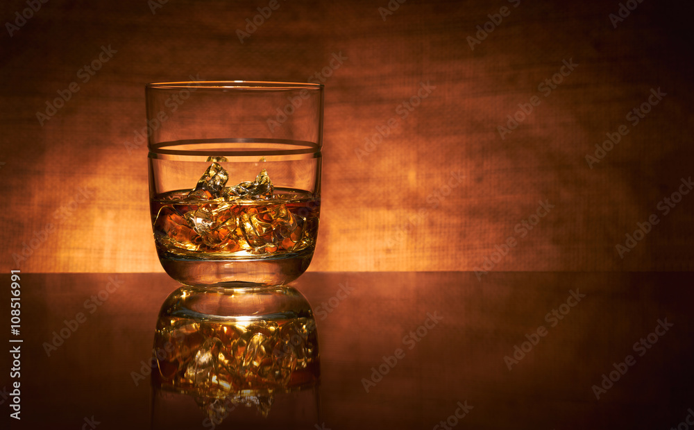A glass of whisky on a reflective bar top surface with no edge highlights.