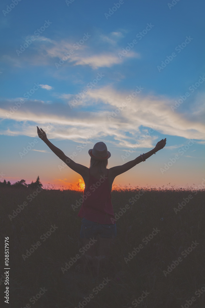 Girl enjoying in a countryside scenic in sunset.
