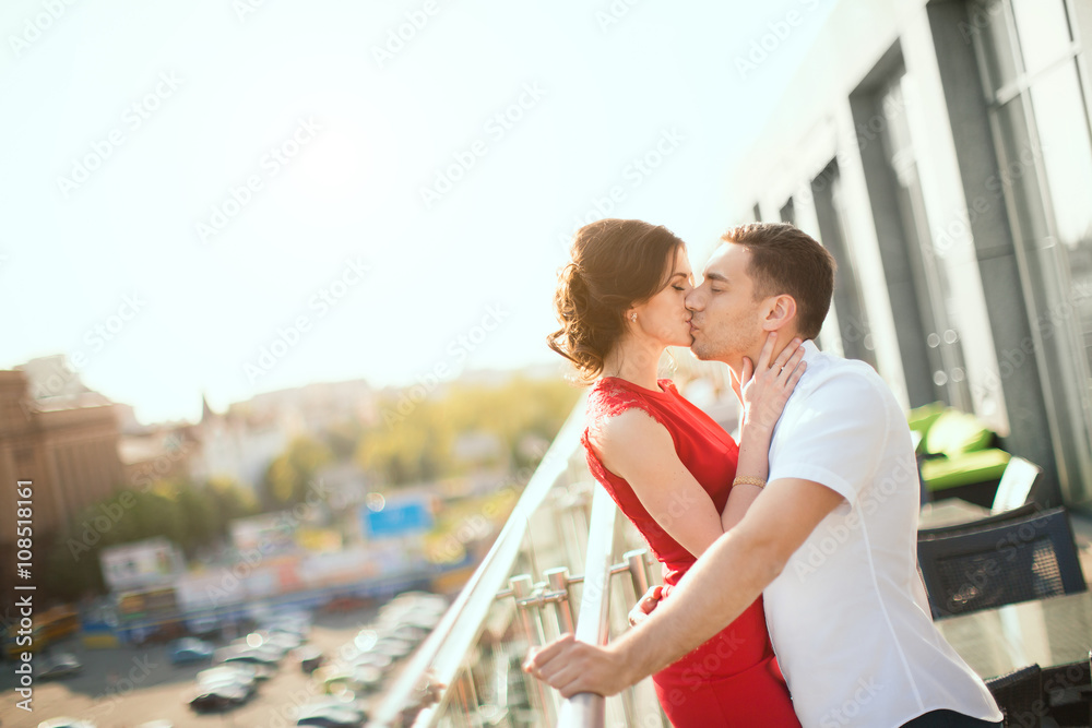 Naklejka premium Happy young couple embraces against view of the city