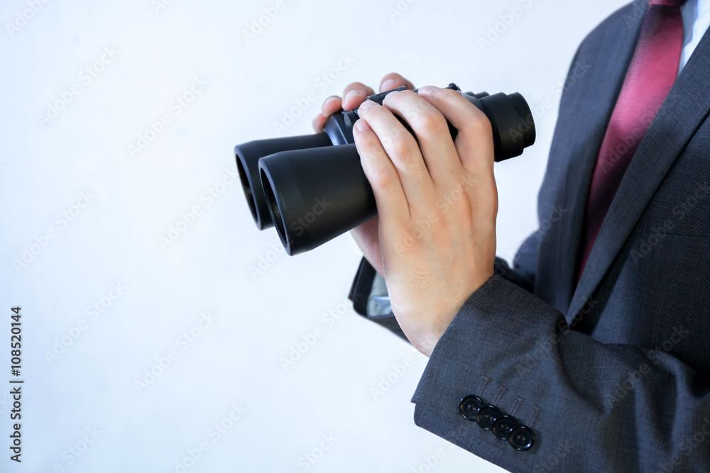 Close-up of Businessman looking for something with binoculars Close-up of Businessman looking for something with binoculars