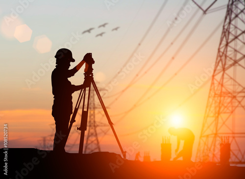 silhouette engineer looking Loaders and trucks in a building sit photo