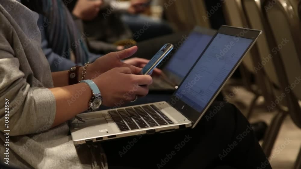 Woman makes phone screenshot of a computer monitor. The background - people with computers. Woman makes phone screenshot of a computer monitor. The background - people with computers.