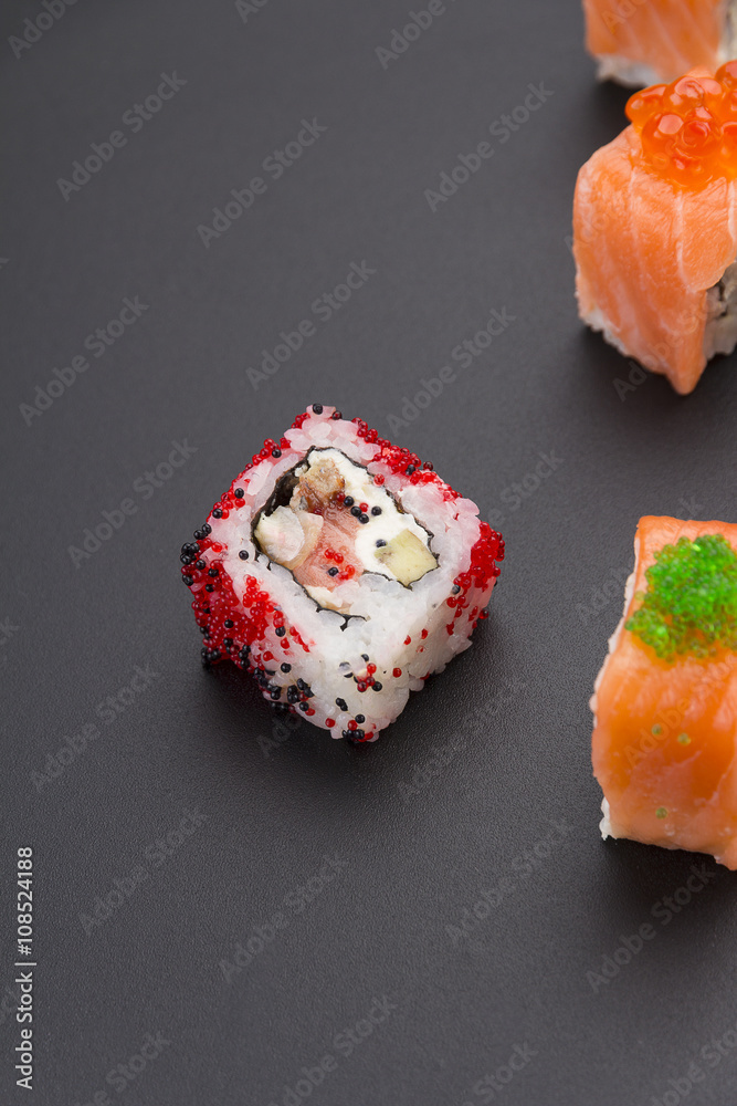 Japanese cuisine. Set of sushi mix roll with differen fresh ingredients over black background ( table ). Japanese cuisine. Set of sushi mix roll with differen fresh ingredients over black background ( table ).