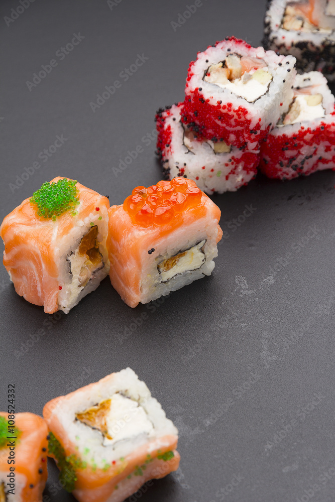 Japanese cuisine. Set of sushi mix roll with differen fresh ingredients over black background ( table ). Japanese cuisine. Set of sushi mix roll with differen fresh ingredients over black background ( table ).