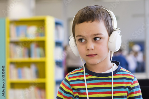 Child with headphones in school or library photo