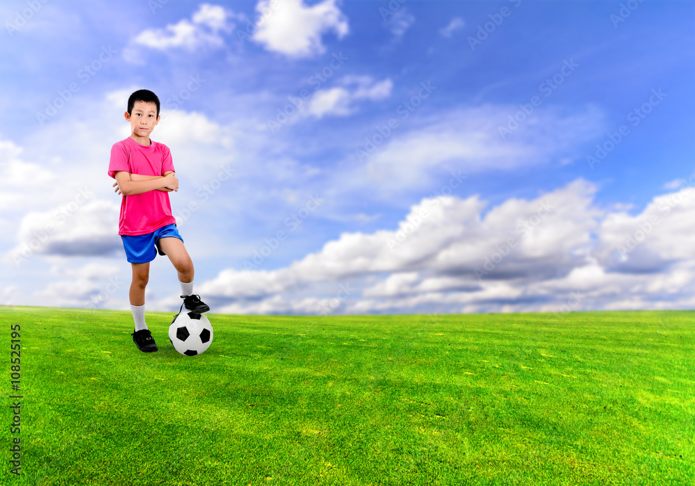 Boy and Soccer ball on green field with blue sky Boy and Soccer ball on green field with blue sky