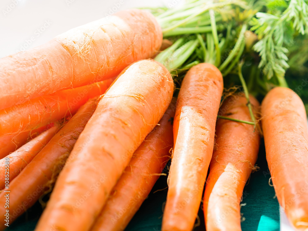 Bunch of carrots on green wooden background Bunch of carrots on green wooden background