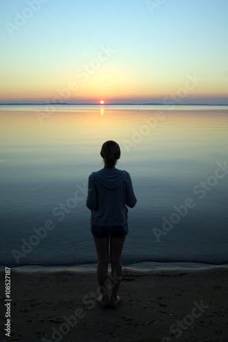 Billede på lærred Girl on the shore beach of the Curonian Spit in Nida (Lithuania) and lonely sunset