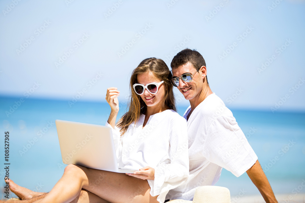 Summer couple using laptop