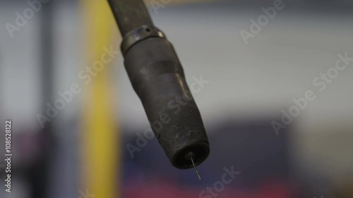 The tip of the welding robot with black small piece on it. Robot welding is the use of mechanized programmable tools (robots) which completely automate a welding process