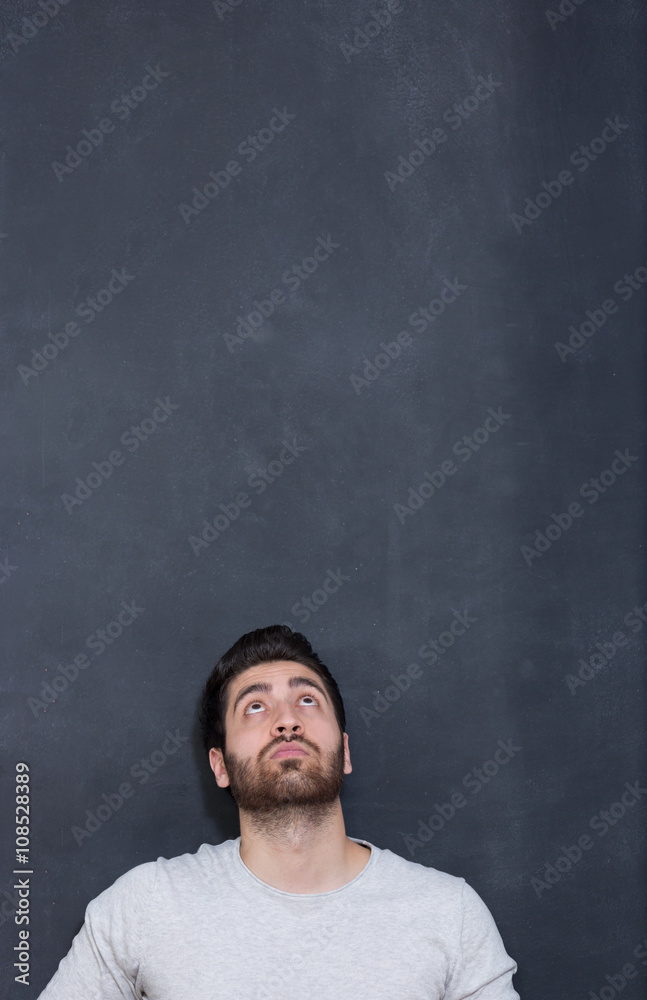 a young man with a beard on a chalkboard background with the emo