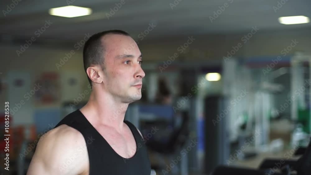 Athletic man running on a treadmill in the gym Athletic man running on a treadmill in the gym