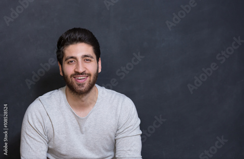 Young handsome man with great smile on the black background